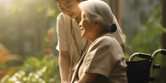 車椅子の高齢女性と、その横で優しく微笑む介護スタッフのイメージ