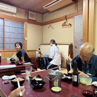 懇親会の席で、料理を楽しみながら笑顔で交流を深める社員の様子